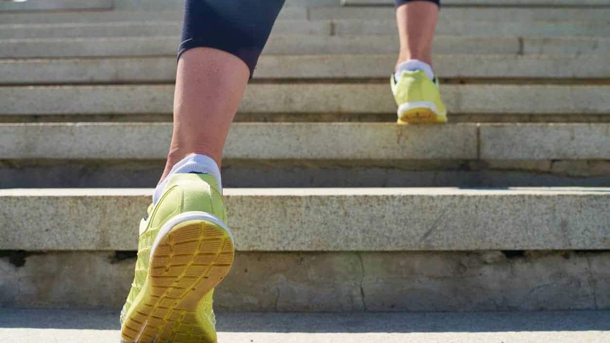 Woman in yellow sneakers runs up a set of stairs for exercise