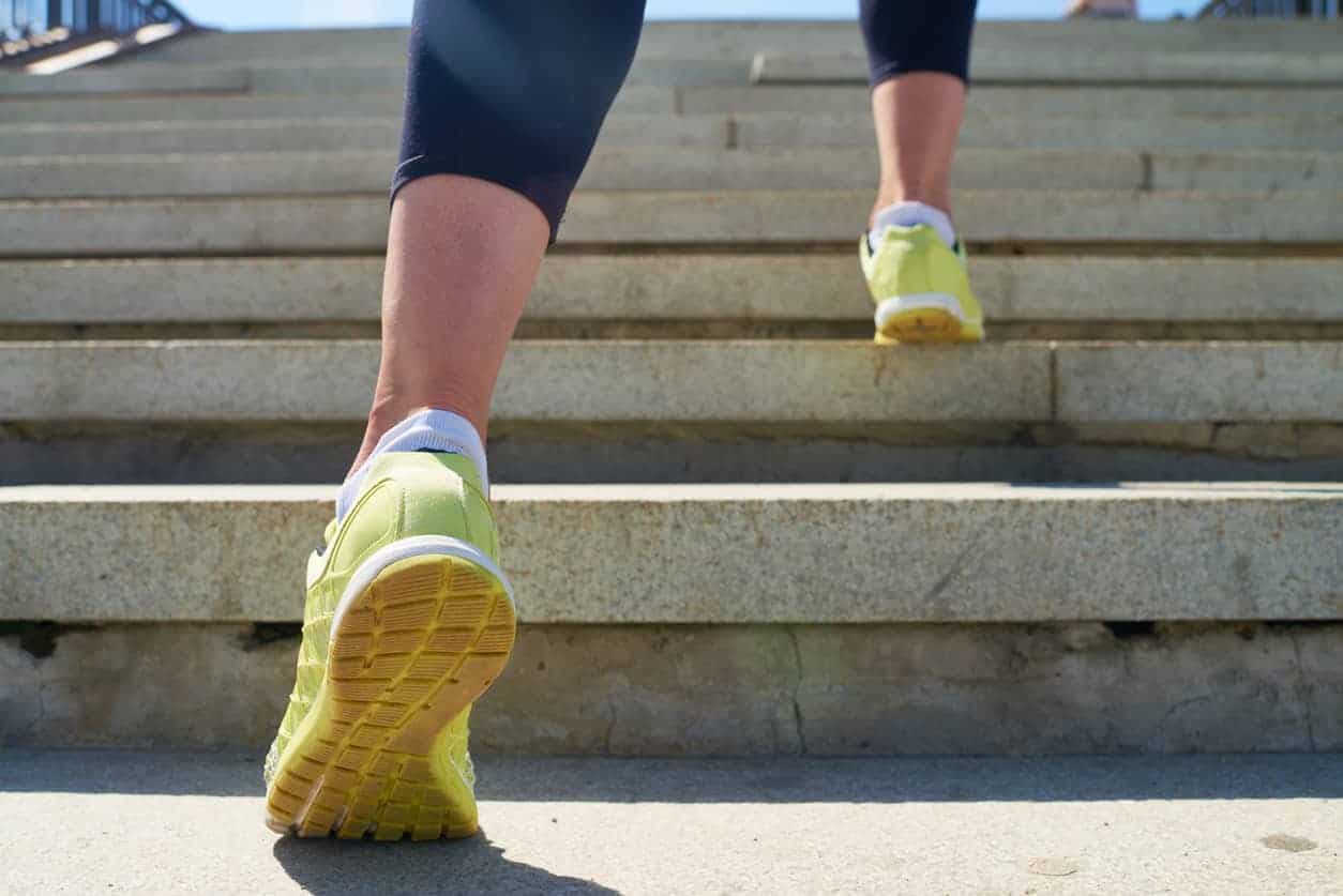 Woman in yellow sneakers runs up a set of stairs for exercise